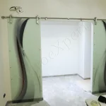 Parete divisoria su misura serigrafata con porta scorrevole aperta e decorazione a mano Roma VetroeXpert Porte in vetro su misura e Pareti divisorie scaled