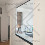 Divisorio di arredo in vetro tra cucina e soggiorno