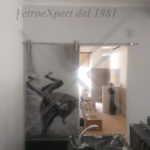porta in vetro decorata con carrucole in acciaio